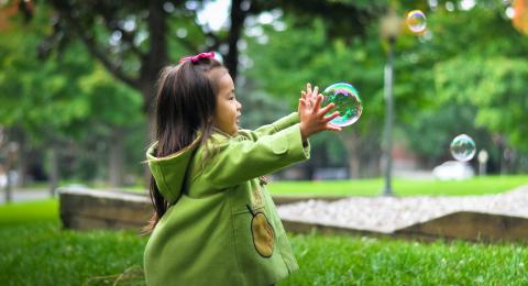 Child catching bubbles